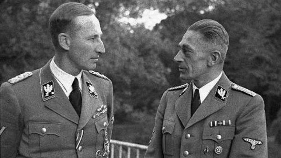 Dva Němci v hovoru, nebo Němec Heydrich rozmlouvá s Čechem Frankem, nebo říšský Němec hledí na českého Němce. Tři možnosti a všechny tři jsou správné. 